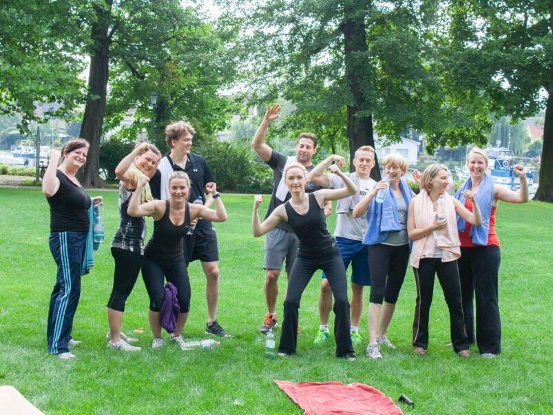 Menschen bejubeln Erfolg ihres Outdoor-Trainings.